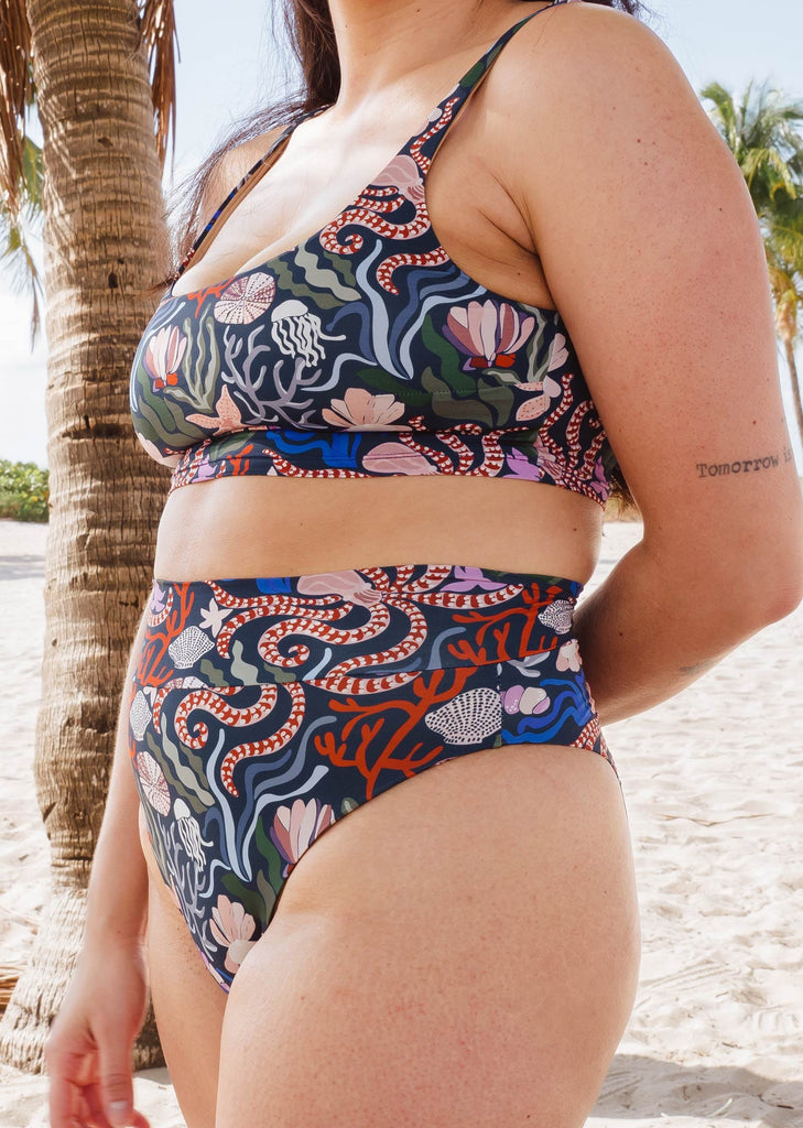 Une femme portant le bas de bikini taille haute imprimé vie marine de mimi et august 