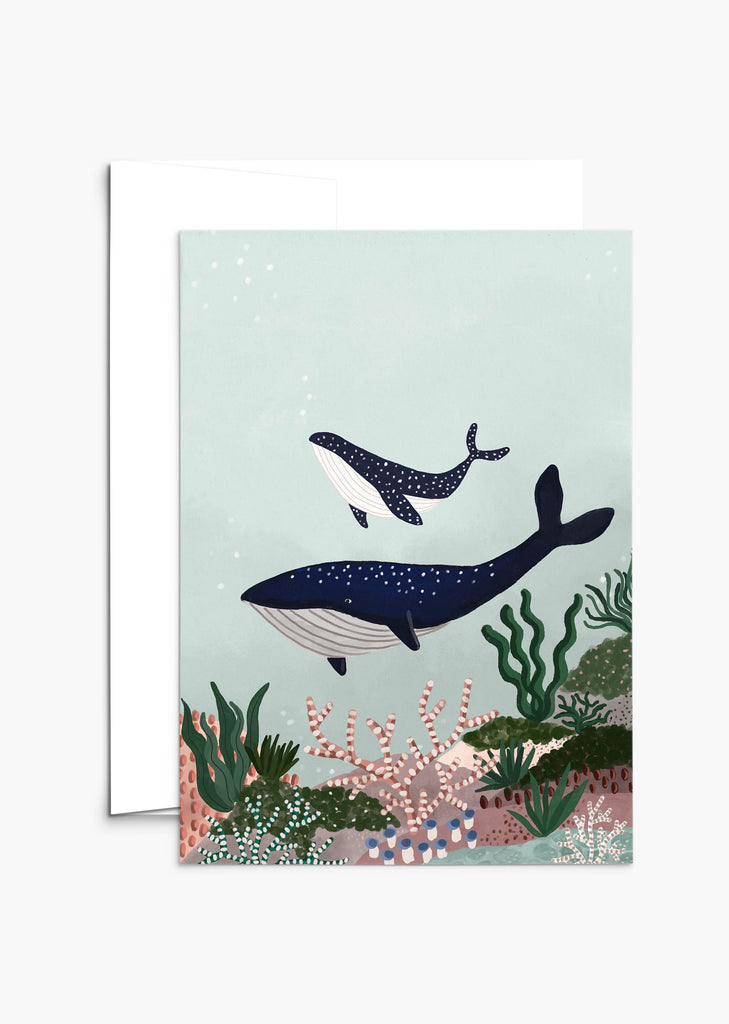 A Mimi & August Mother's Day greeting card displaying an illustration of two whales swimming underwater, surrounded by various forms of sea life and coral, set against a pale green background.