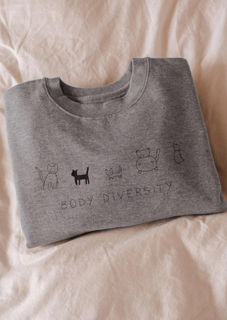 Un confortable sweat-shirt Mimi & August Body Diversity pour femmes avec un chat dessus.
