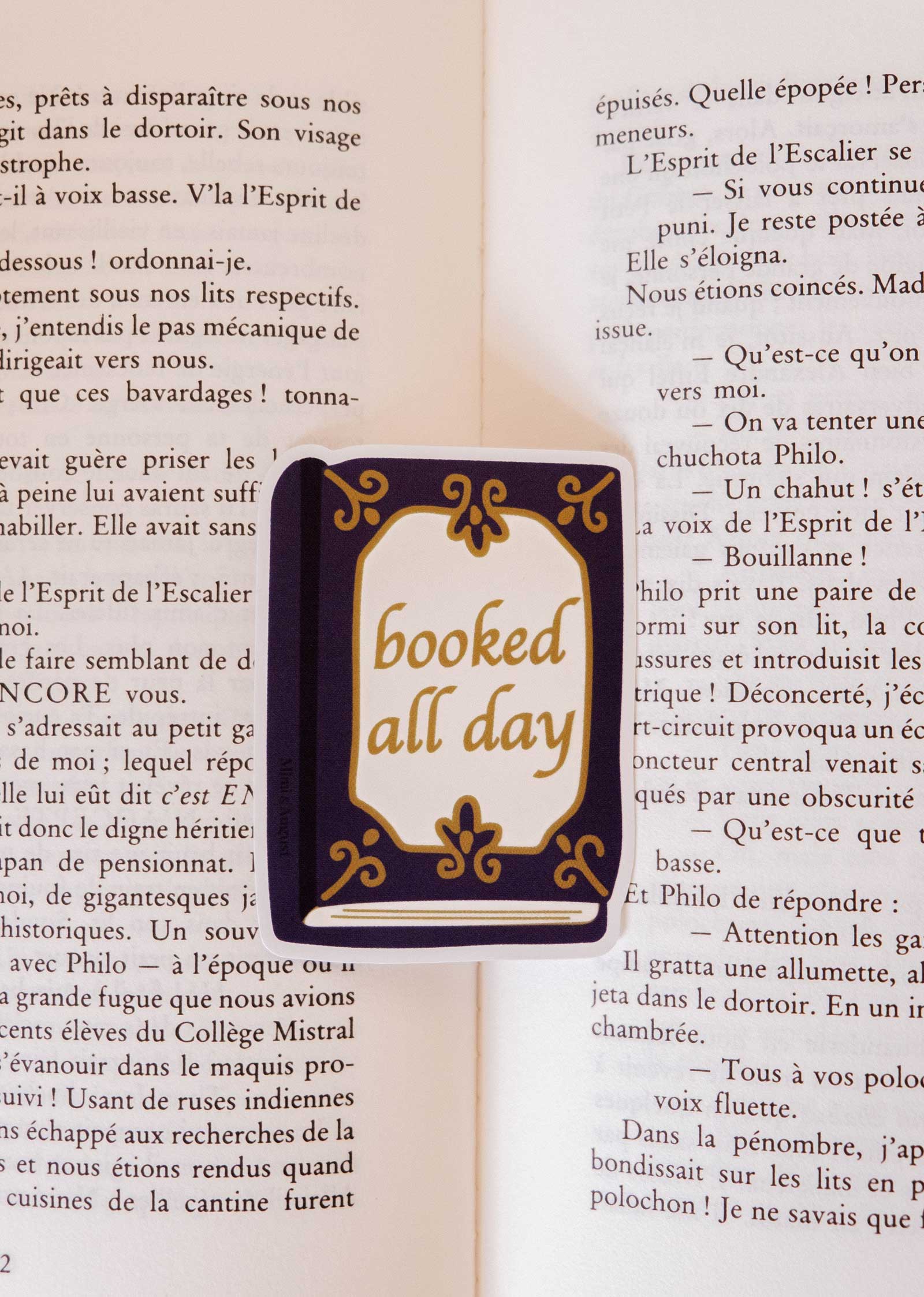 The Booked All Day - Vinyl Sticker by Mimi & August is a rectangular vintage book sticker featuring the phrase "booked all day," ideal as a reading journal accessory.
