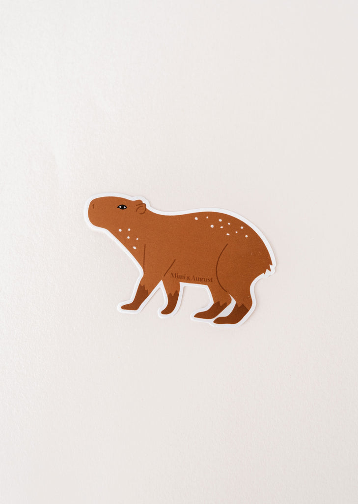 A waterproof Mimi & August vinyl sticker featuring a Capybara on a white surface.