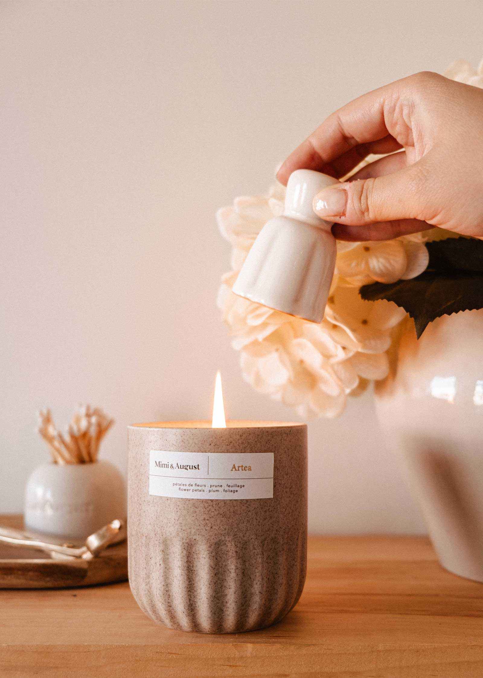 Handmade ceramic candle snuffer extinguishing candle flame with elegant minimalist design