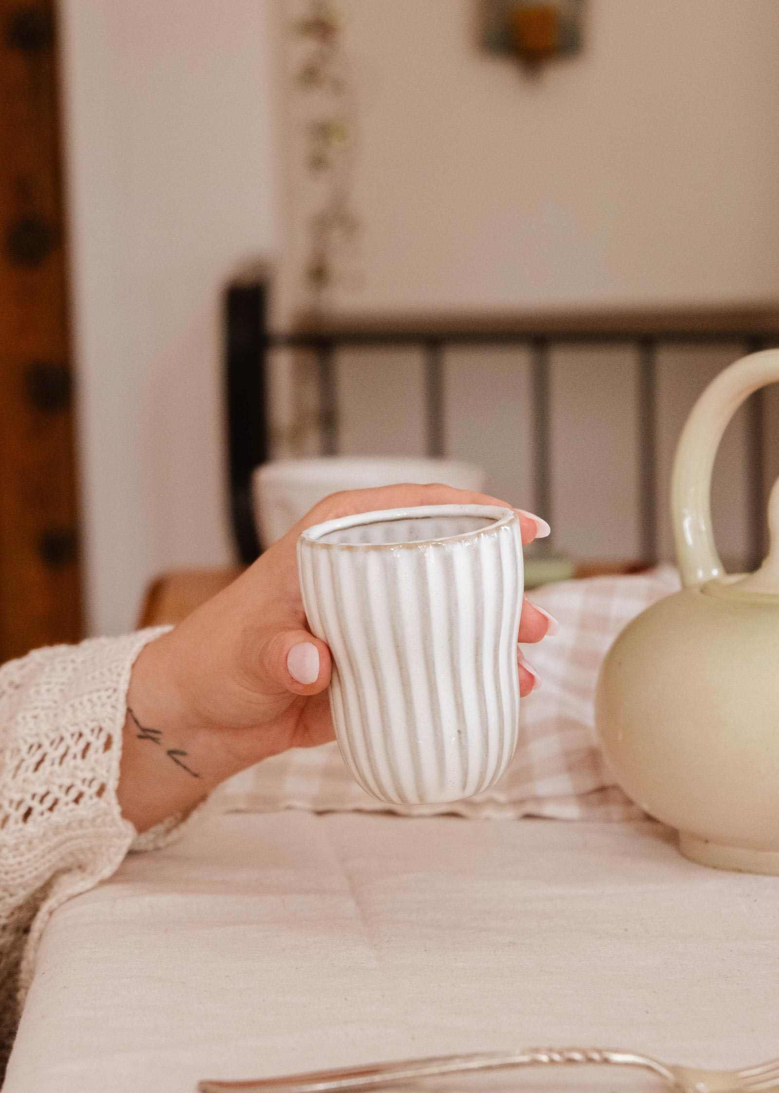 Handmade ceramic espresso cup with ribbed detailing and soft cream glaze, handleless design