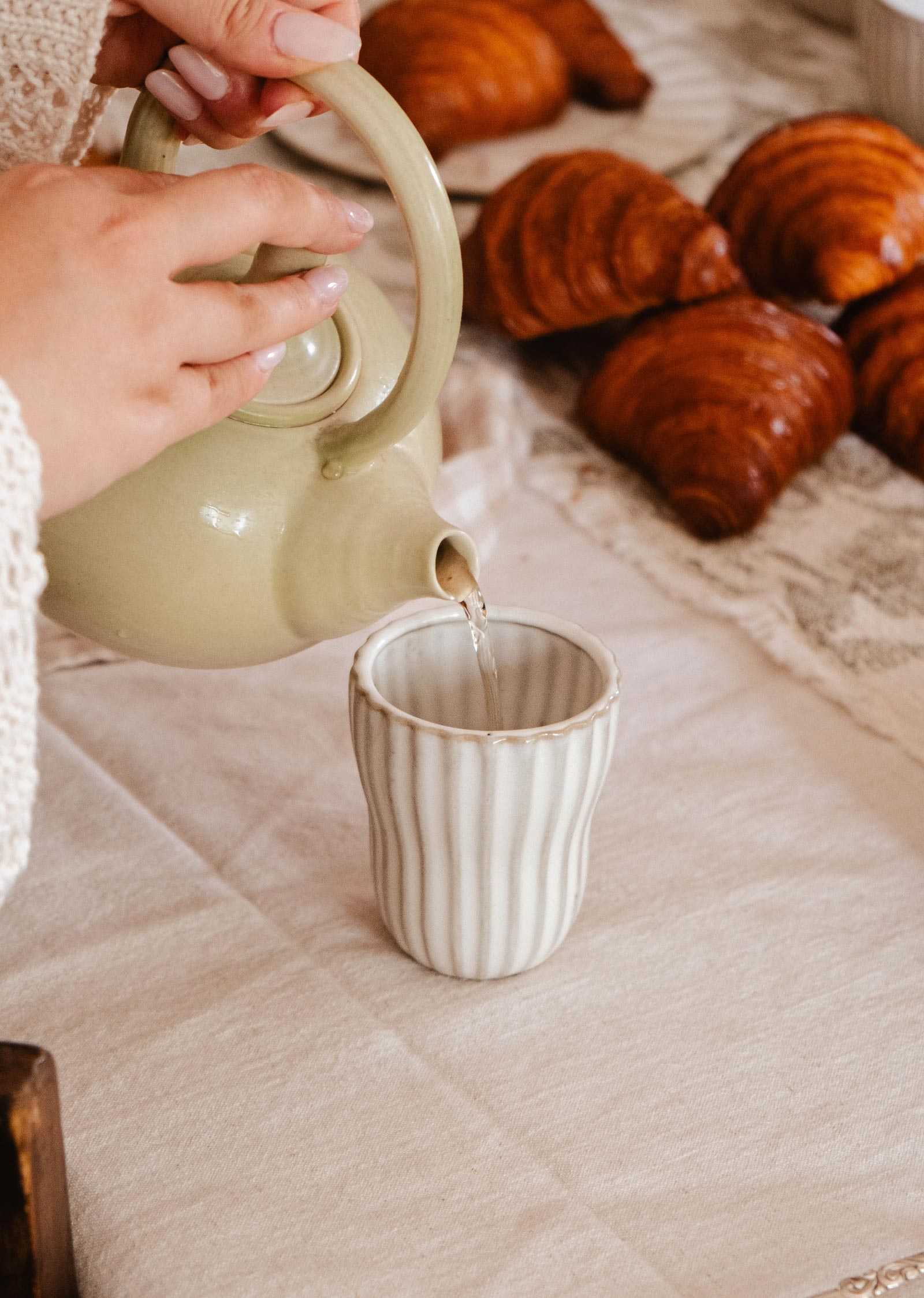 Handmade ceramic espresso cup with ribbed texture and soft cream glaze
