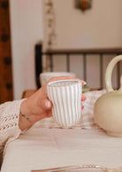 Handmade ceramic espresso cup with ribbed detailing and soft cream glaze, handleless design