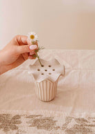 Handmade ceramic flower frog with scalloped edge on glass jar holding wildflower stems