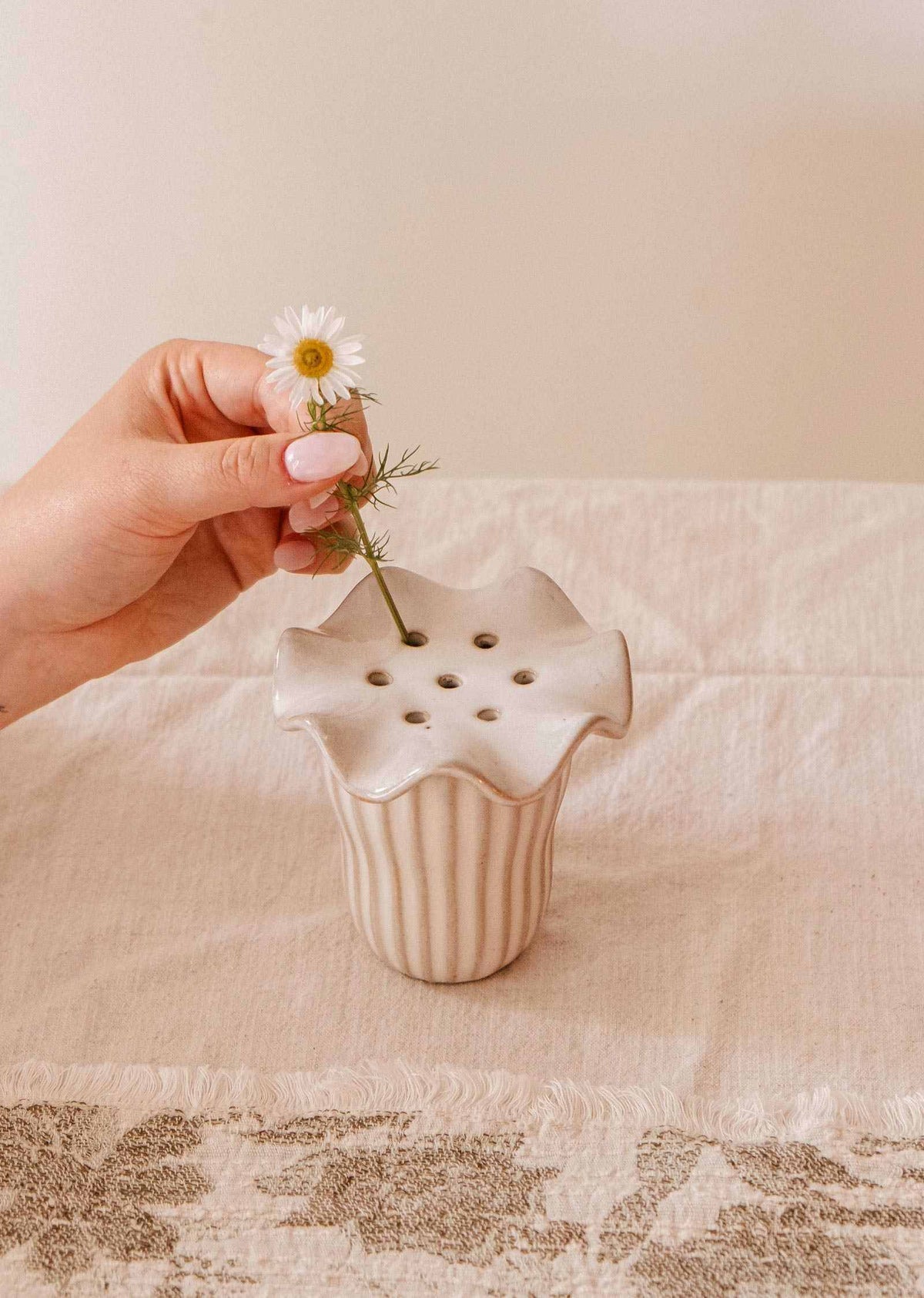 Handmade ceramic flower frog with scalloped edge on glass jar holding wildflower stems