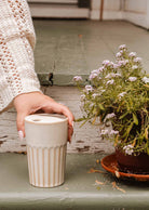 Handmade ceramic to-go cup with ribbed grip and fitted lid