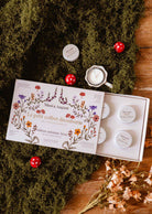 fall candle gift set with six white soy tealights in a floral illustrated discovery box
