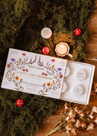 fall candle gift set with six soy tealights in a floral illustrated winter discovery box
