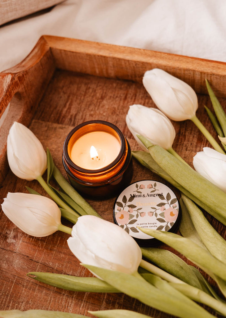 A Fleurette - Reusable Candle tray adorned with white tulips and a candle, showcasing the beauty of nature's wild flowers, from Mimi & August.