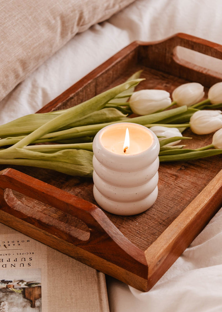 A Fleurette - Reusable Candle by Mimi & August on a wooden tray, showcasing the natural beauty of wild flowers.