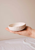 Handcrafted ceramic candle holder Little Ceramic Nest holding a candle refill with minimalist textured design