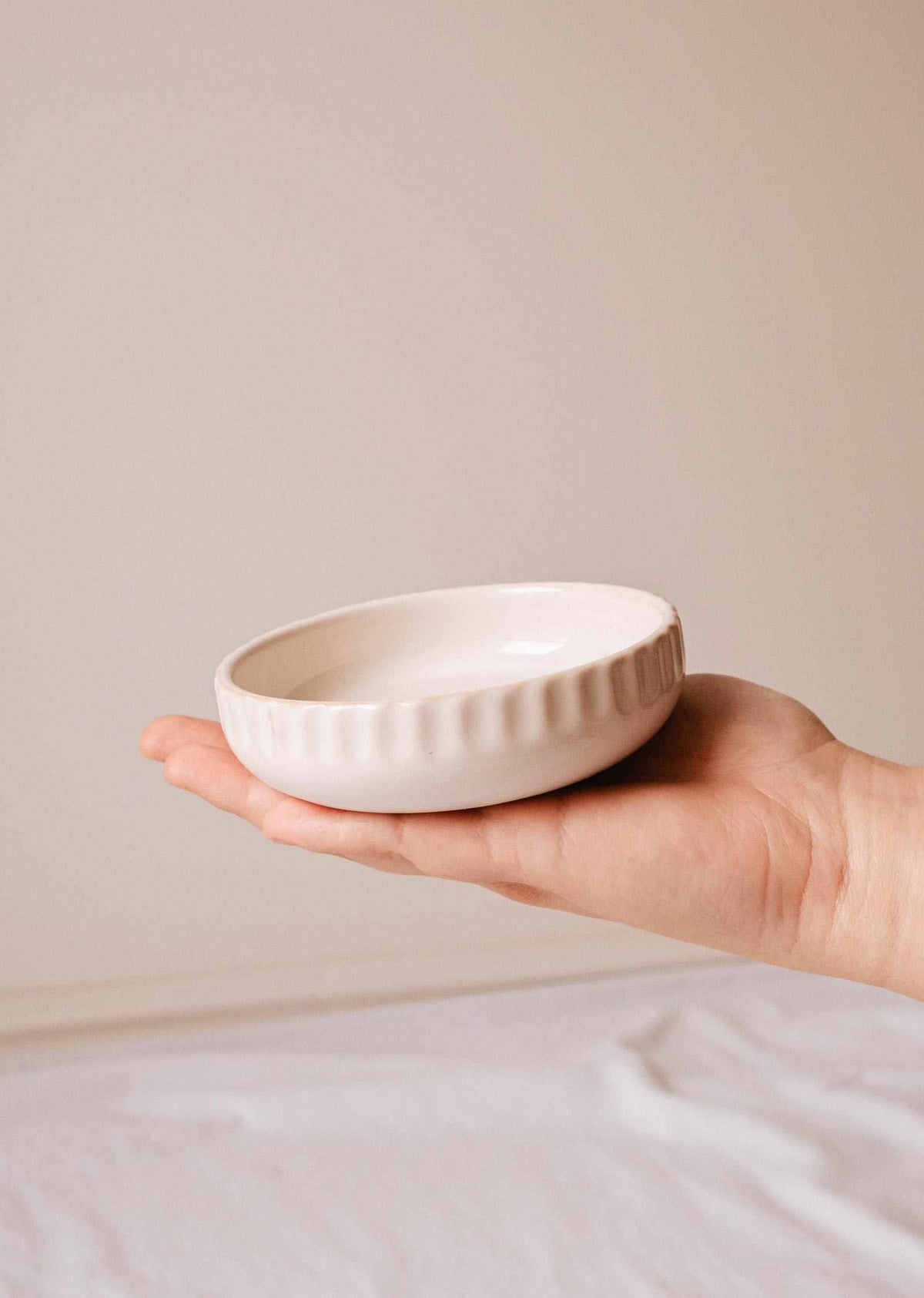 Handcrafted ceramic candle holder Little Ceramic Nest holding a candle refill with minimalist textured design