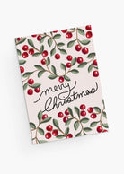 The Merry Christmas Greeting Card by Mimi & August features a red berry and green leaf pattern, "Merry Christmas" in handwritten text, is printed on recycled paper, and comes blank inside for your own message.