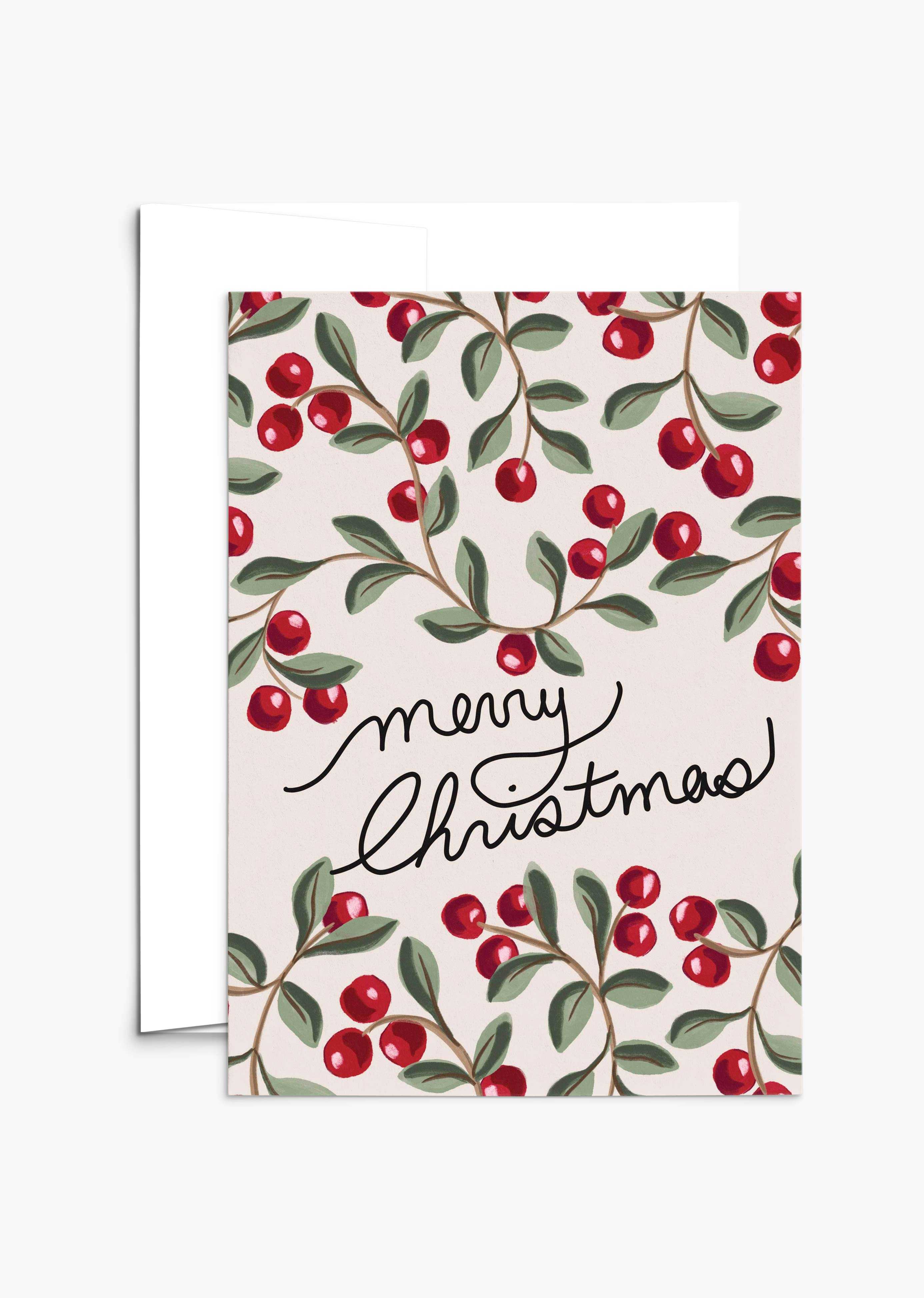 The Merry Christmas Greeting Card by Mimi & August features "Merry Christmas" in cursive with red berries and green leaves on a light background. Printed on recycled paper, it's blank inside for your message.