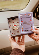 Diffuseur pour voiture Champignon rond en émail crème et doré, orné d’un champignon rouge et de motifs floraux délicats.