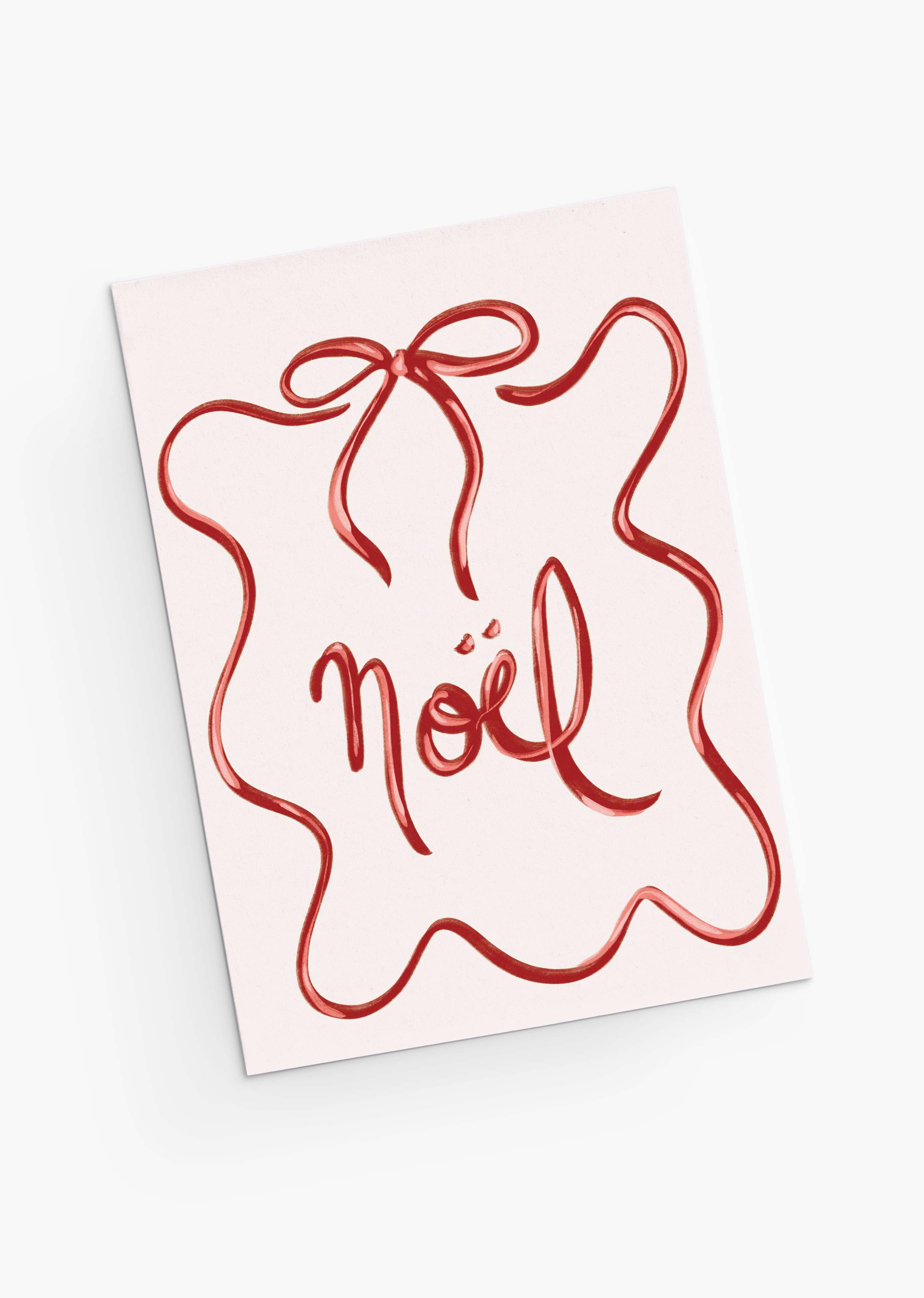 The Mimi & August Christmas Bow Greeting Card features "Noël" in red cursive, framed by a red squiggly ribbon like a gift bow. Printed on recycled paper, it's blank inside for your personal message.