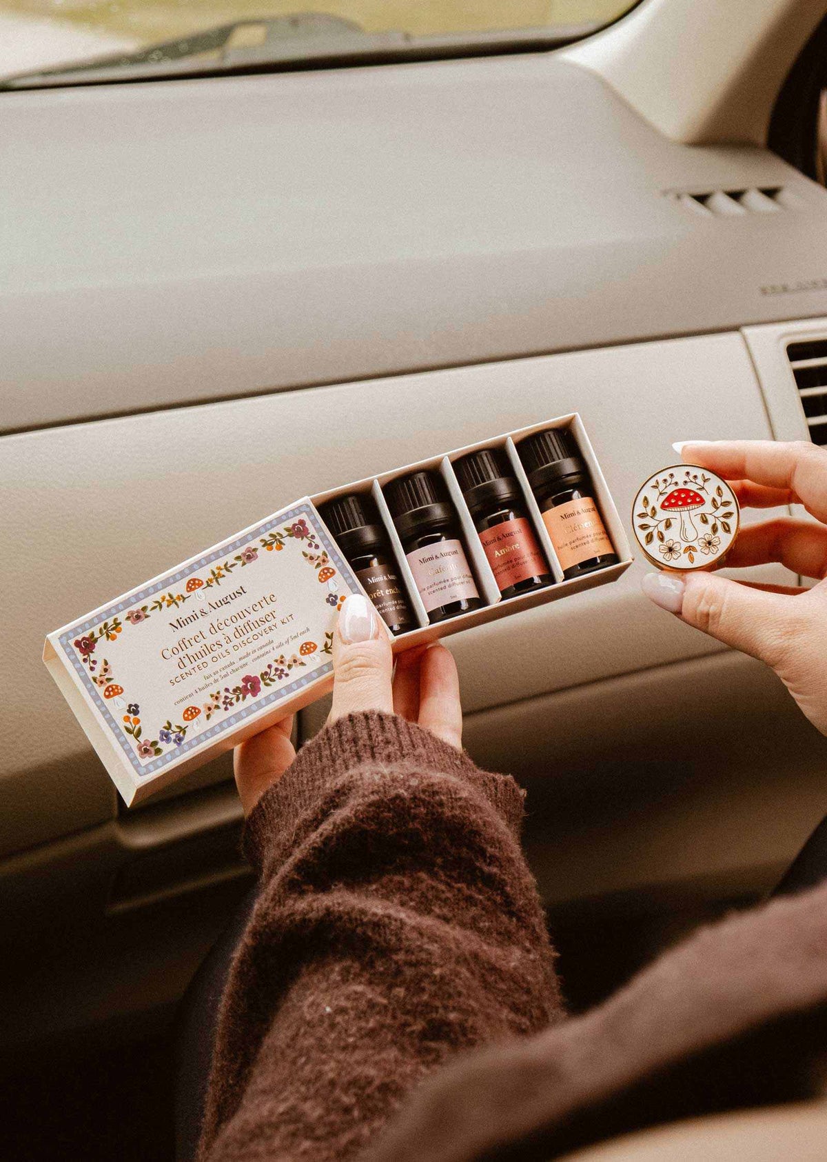 Coffret découverte d’Huiles Parfumées avec quatre flacons ambrés et étiquettes colorées, présenté dans une boîte fleurie.