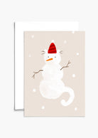 Chat en forme de bonhomme de neige avec un joli chapeau de Père Noël rouge, avec des flocons de neige sur toute la carte de vœux. Par Mimi & August