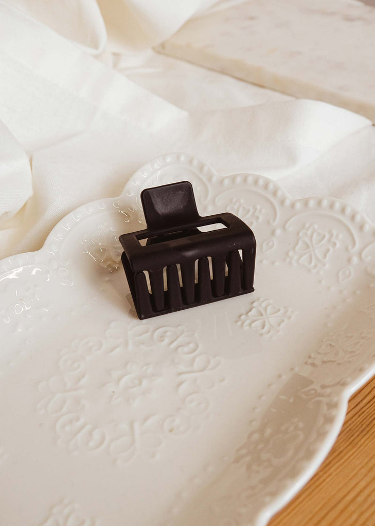 Black matte claw hair clip in a decorative plate by mimi and august