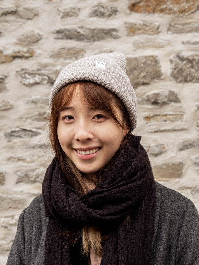 women wearing the heather oatmeal super puff beanie with black scarf