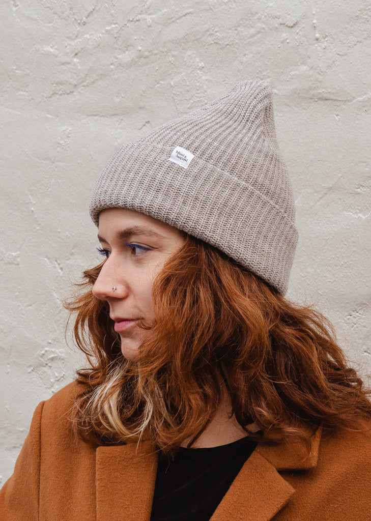 woman smiling and wearing the oatmeal super puff beanie