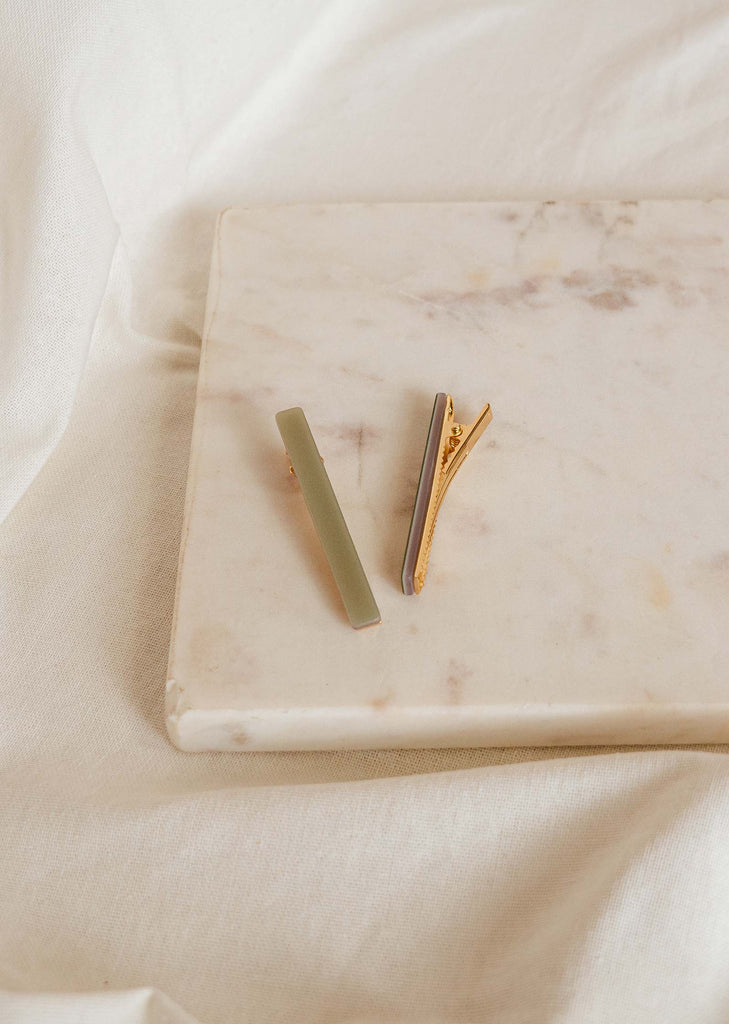 duo of hair clips in the shape of a bar in sage green color on a marble table