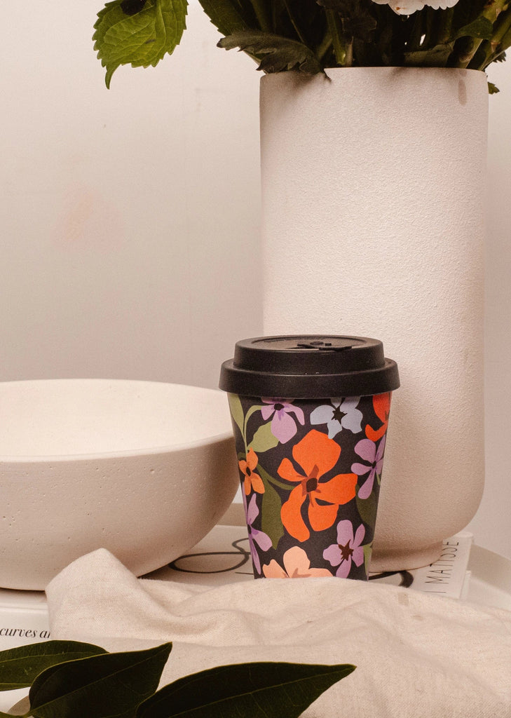 tasse à café noire avec des illustrations de pétales de fleurs par mimi et august