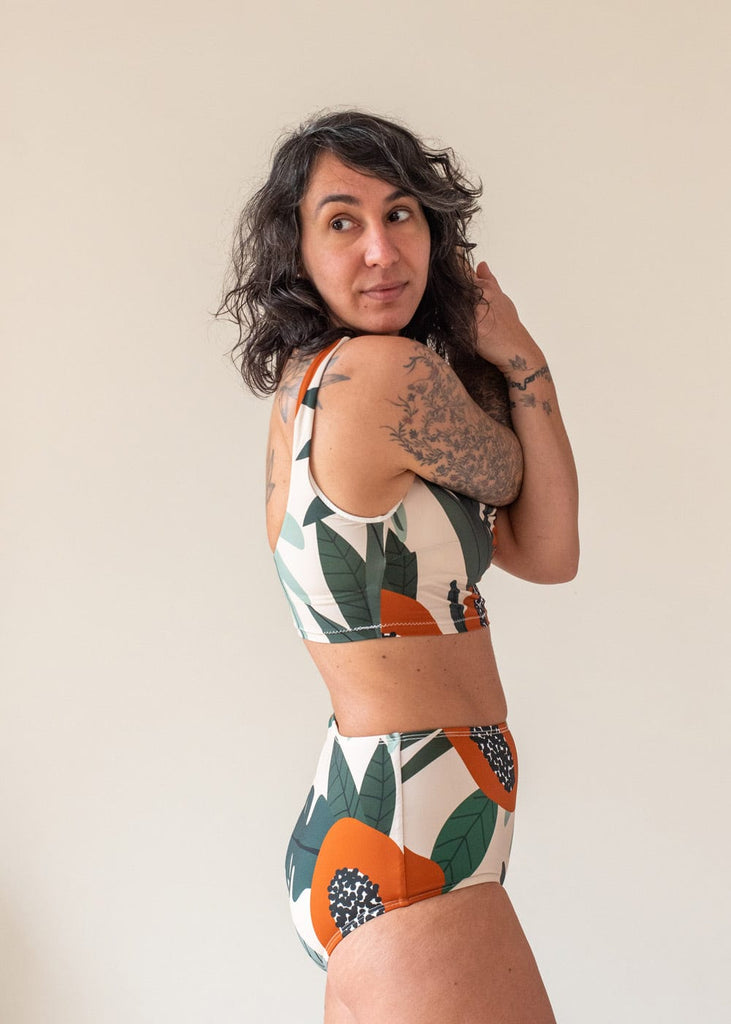Eco-friendly swimwear bikini top with papaya illustrations wear by Emma