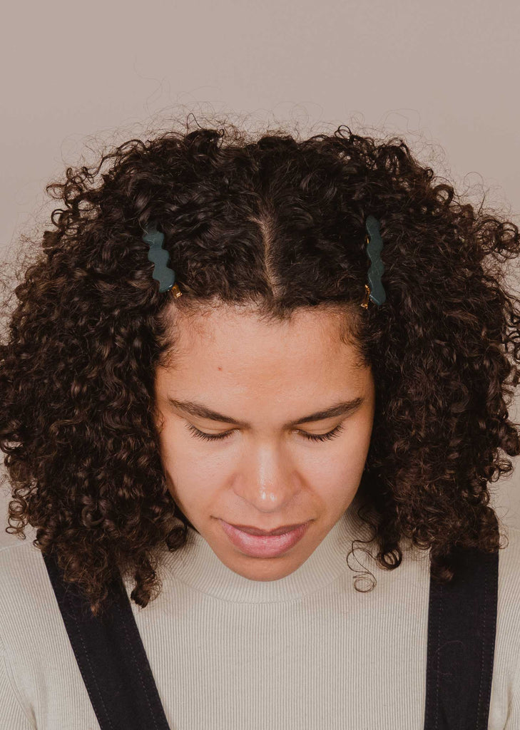 laura porte une paire de pinces à cheveux Tropica en forme de vague créant une coiffure