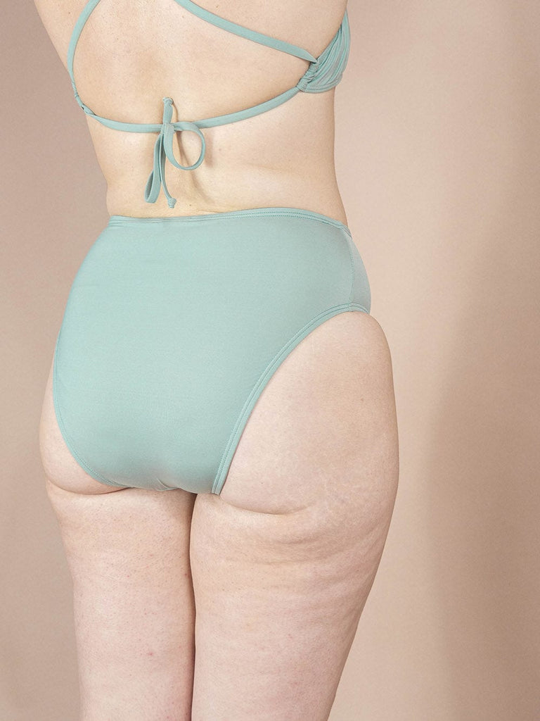 Dos d'une femme en bas de bikini Tucan Agave à jambe haute et taille haute de Mimi & August, arborant un bikini vert.