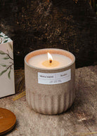 lit reusable soy campfire candle in ceramic container with natural wood background
