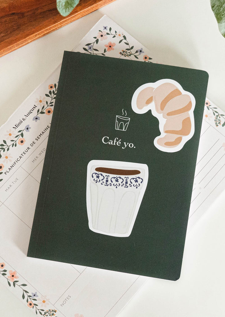 notebook with croissant sticker and coffee