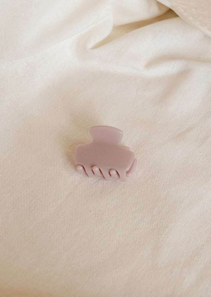 Small lilac colored hair clip on a tablecloth