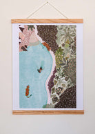 Swimming with Tigers Art Print hanging with wooden frame showing tiger swimming in blue water surrounded by lush greenery illustration
