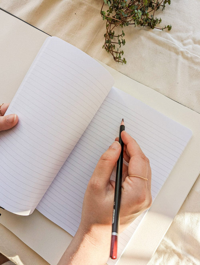 écrire des poèmes au crayon sur un cahier par mimi & august